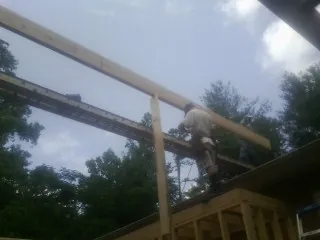 Carpenter setting a ridge beam over a new addition frame — Ice Dam Removal by Roofing Brothers in Dolton
