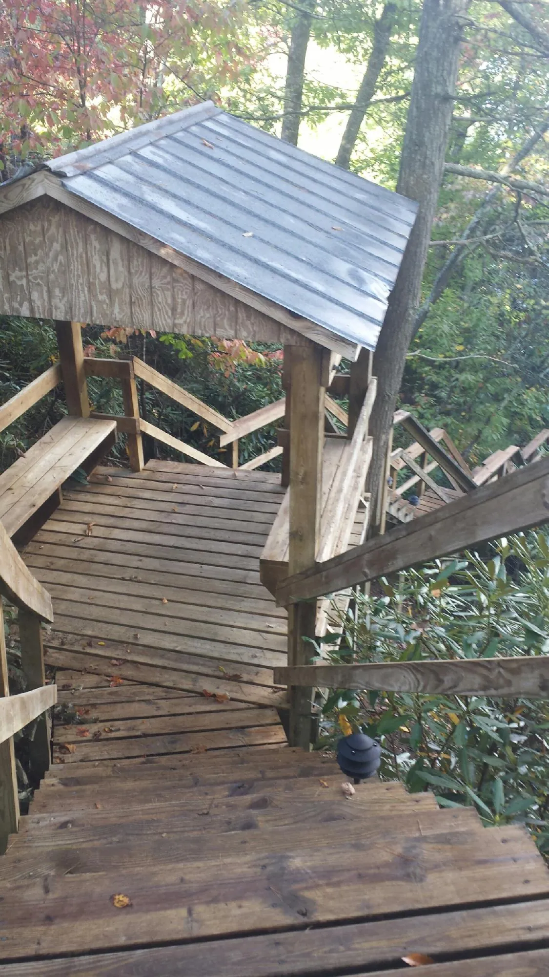 Metal roofed shelter over wooden steps on a wooded walkway — Skylight Repair & Installation work by our crew in Dolton