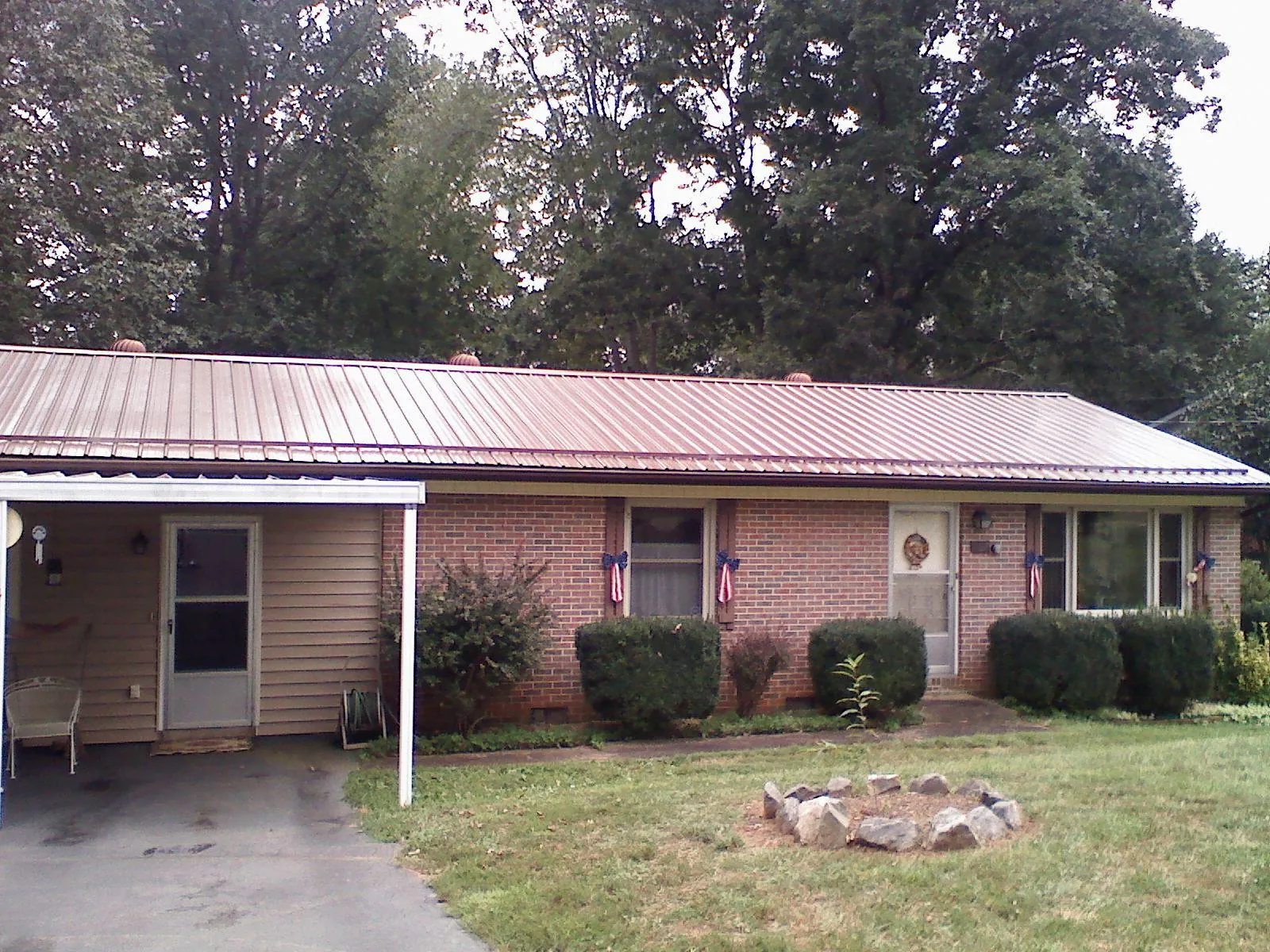 Bronze metal roof and carport on a brick ranch home — Roof Repair work by our crew in Dolton